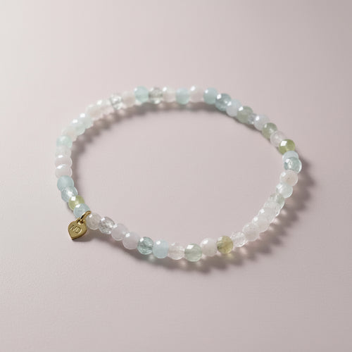 The Mermaid's Den Astilbe Morganite beaded bracelet with soft blush and peach gradient gemstones and a gold heart charm