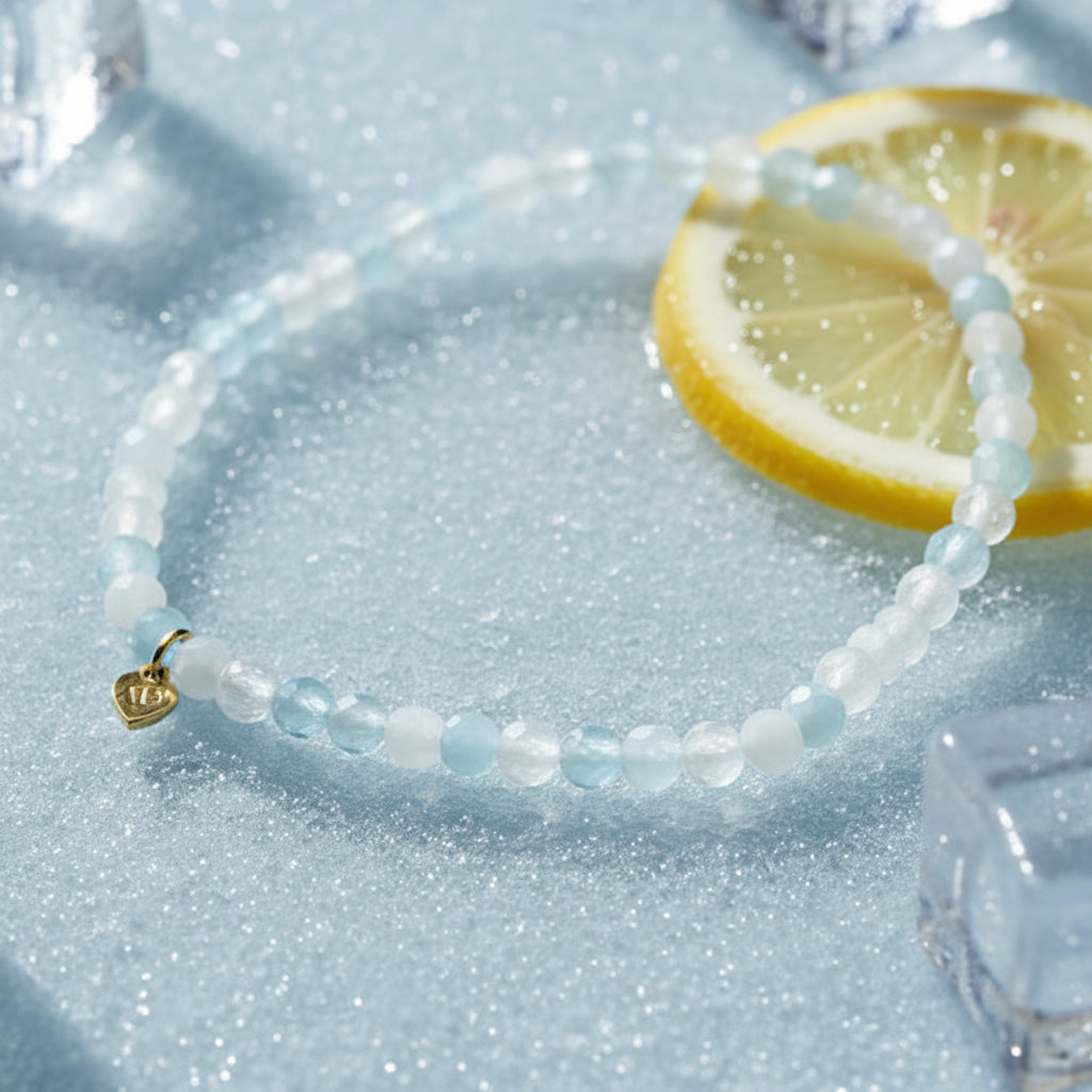 The Mermaid's Den Hyacinth bracelet featuring faceted milky aquamarine beads in soft blue and white with a gold heart charm
