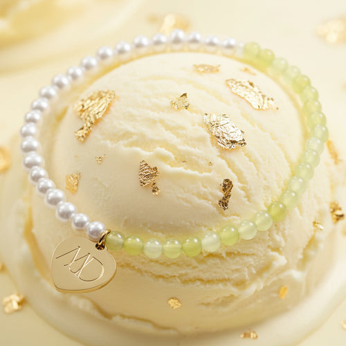 The Mermaid's Den Didiscus bracelet featuring transparent yellow jade beads, aquamarine pearls, and a gold heart charm.